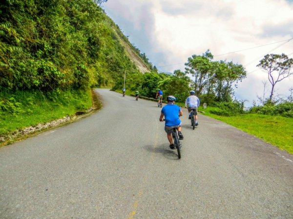 group riding bike down mountain road