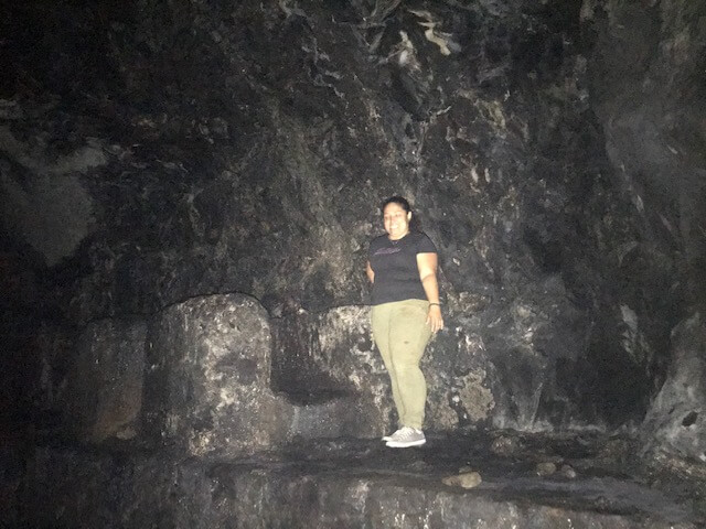 woman standing inside ancient tunnel
