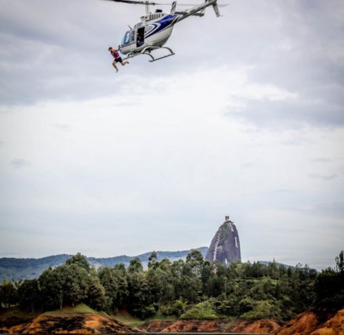 man jumping out of helicopter into lake