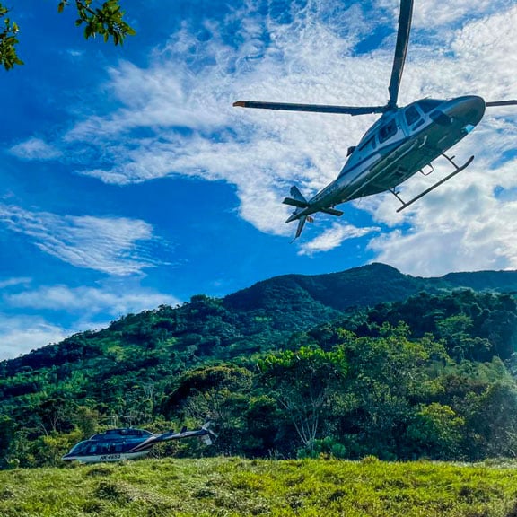 helicopter taking off from a green field