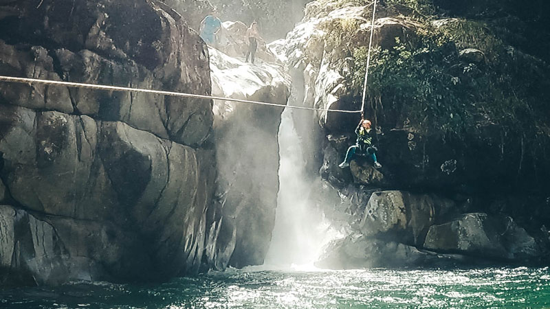 person ziplining into a river