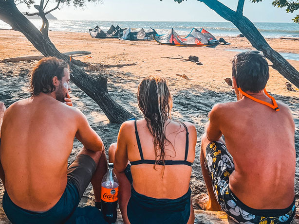 3 kitesurfers sitting on a beach in Colombia
