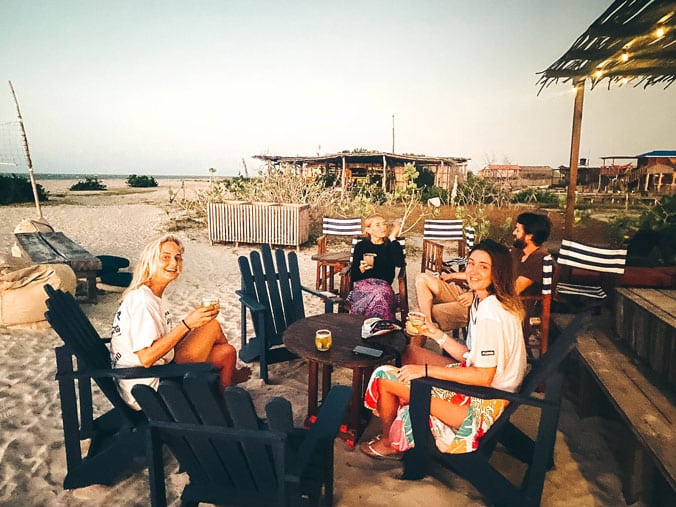 Group of 4 young people sitting on a beach